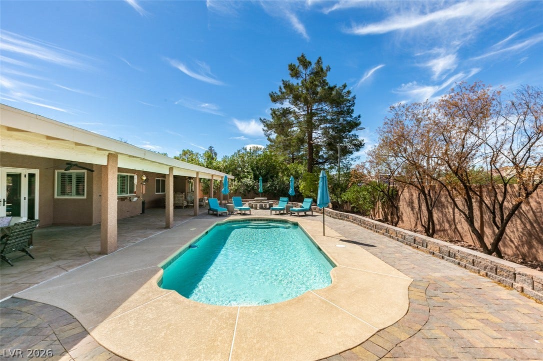 2246 Almart Circle, Henderson, NV 89014 An inviting backyard oasis features a shimmering inground pool surrounded by concrete and paver decking.