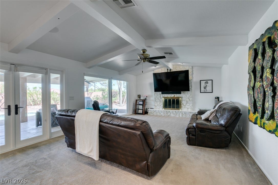 2246 Almart Circle, Henderson, NV 89014 Exposed beams and a stone fireplace create a welcoming focal point in this living area.