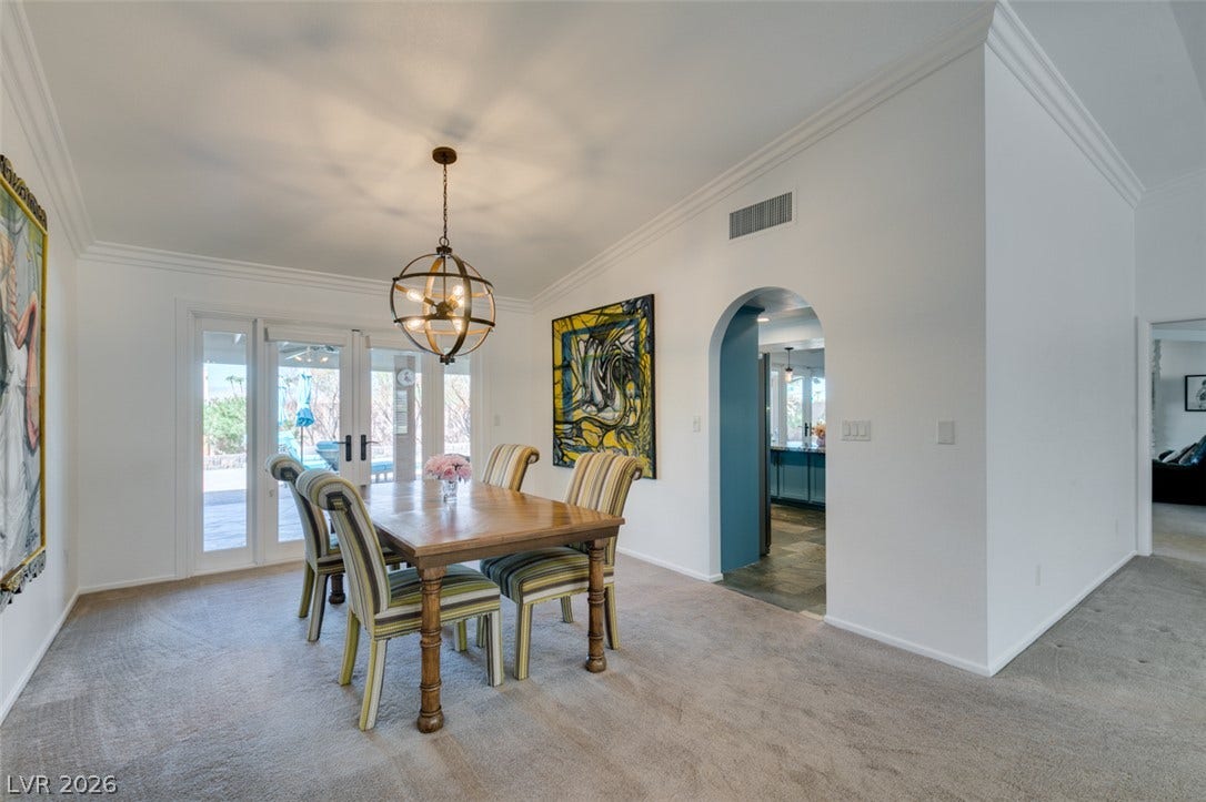 2246 Almart Circle, Henderson, NV 89014 An arched doorway and classic crown molding elevate this carpeted dining space.