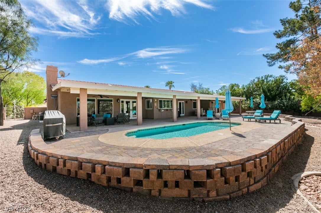 2246 Almart Circle, Henderson, NV 89014 An inviting backyard oasis centers around a sparkling swimming pool and covered concrete patio.
