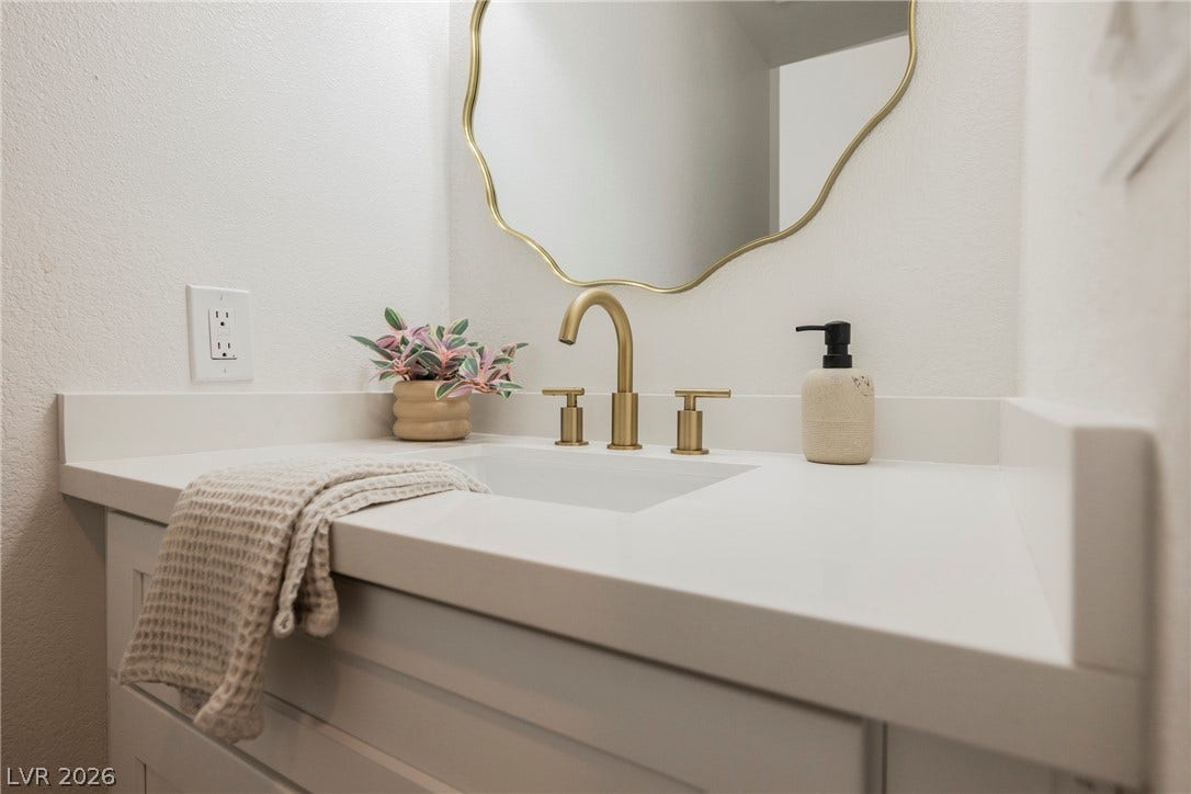 4877 Fiesta Lakes Street, Las Vegas, NV 89130 A sleek modern vanity features clean lines and a contemporary gold faucet setup.