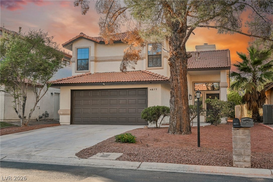 4877 Fiesta Lakes Street, Las Vegas, NV 89130 Spanish tile roofing and stucco siding define this two-story residence with an attached garage.