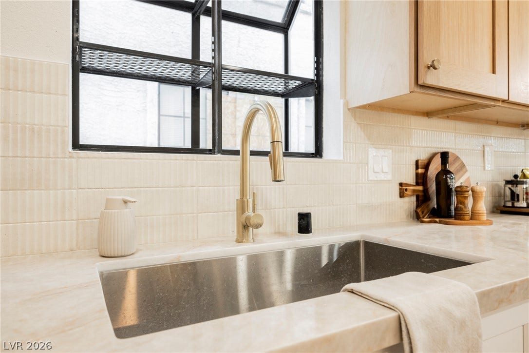 4877 Fiesta Lakes Street, Las Vegas, NV 89130 Gleaming stone countertops frame an undermount sink below a garden window structure.