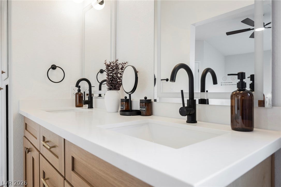 4877 Fiesta Lakes Street, Las Vegas, NV 89130 A spacious double vanity features clean white countertops and modern matte black hardware.