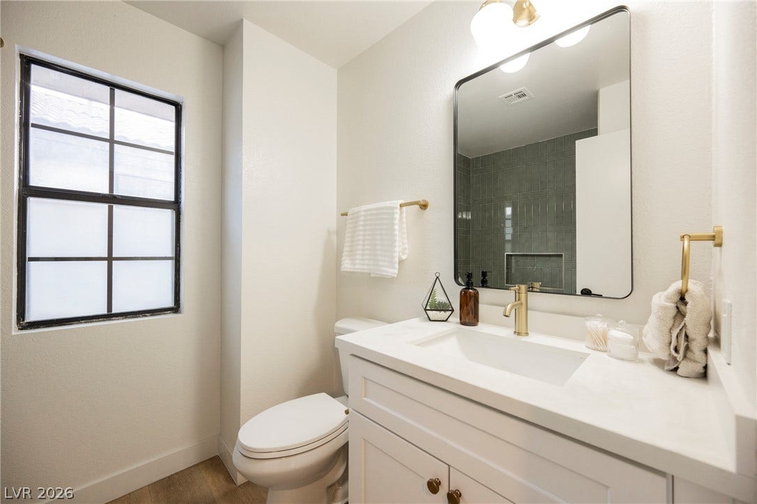 4877 Fiesta Lakes Street, Las Vegas, NV 89130 Clean lines and modern brass fixtures define this updated bathroom space.
