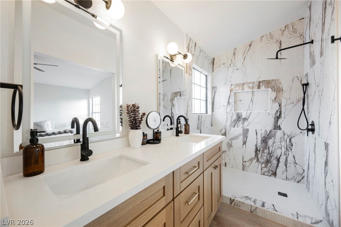 4877 Fiesta Lakes Street, Las Vegas, NV 89130 A sleek double vanity coordinates beautifully with the custom tiled walk-in shower.