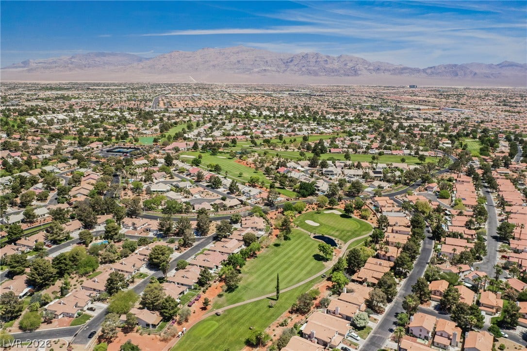 4877 Fiesta Lakes Street, Las Vegas, NV 89130 A sweeping neighborhood overview highlights the green fairway and distant desert mountains.