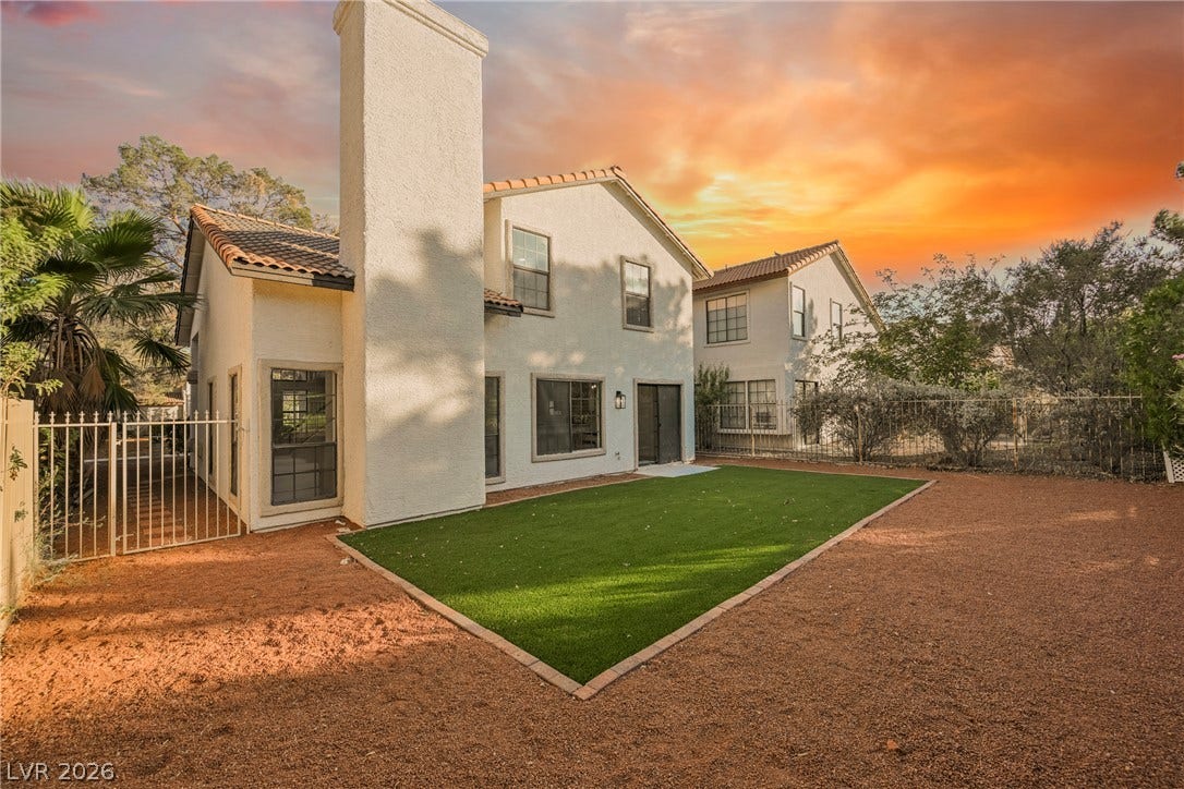 4877 Fiesta Lakes Street, Las Vegas, NV 89130 An inviting backyard features low-maintenance synthetic turf and a stucco exterior beneath tile roofing.