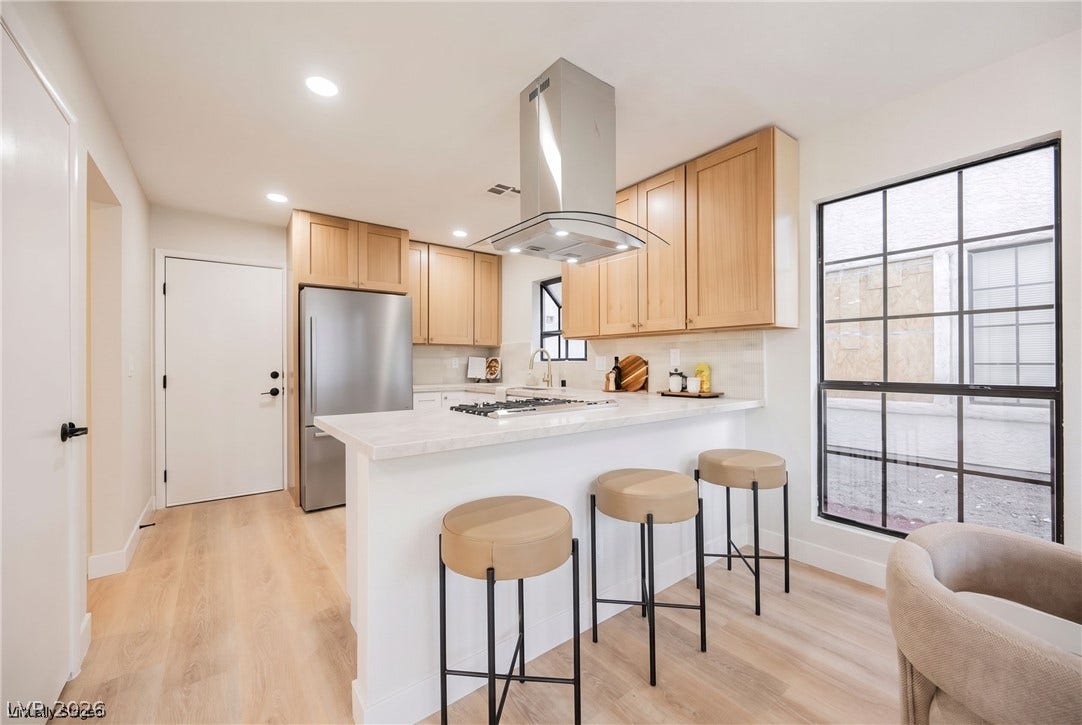 4877 Fiesta Lakes Street, Las Vegas, NV 89130 Warm wood cabinetry and durable hard-surface flooring frame this efficient kitchen layout.