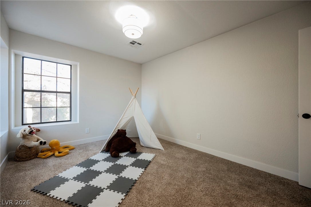4877 Fiesta Lakes Street, Las Vegas, NV 89130 Plush carpeting and a multi-lite window create a comfortable setting in this flexible secondary bedroom.