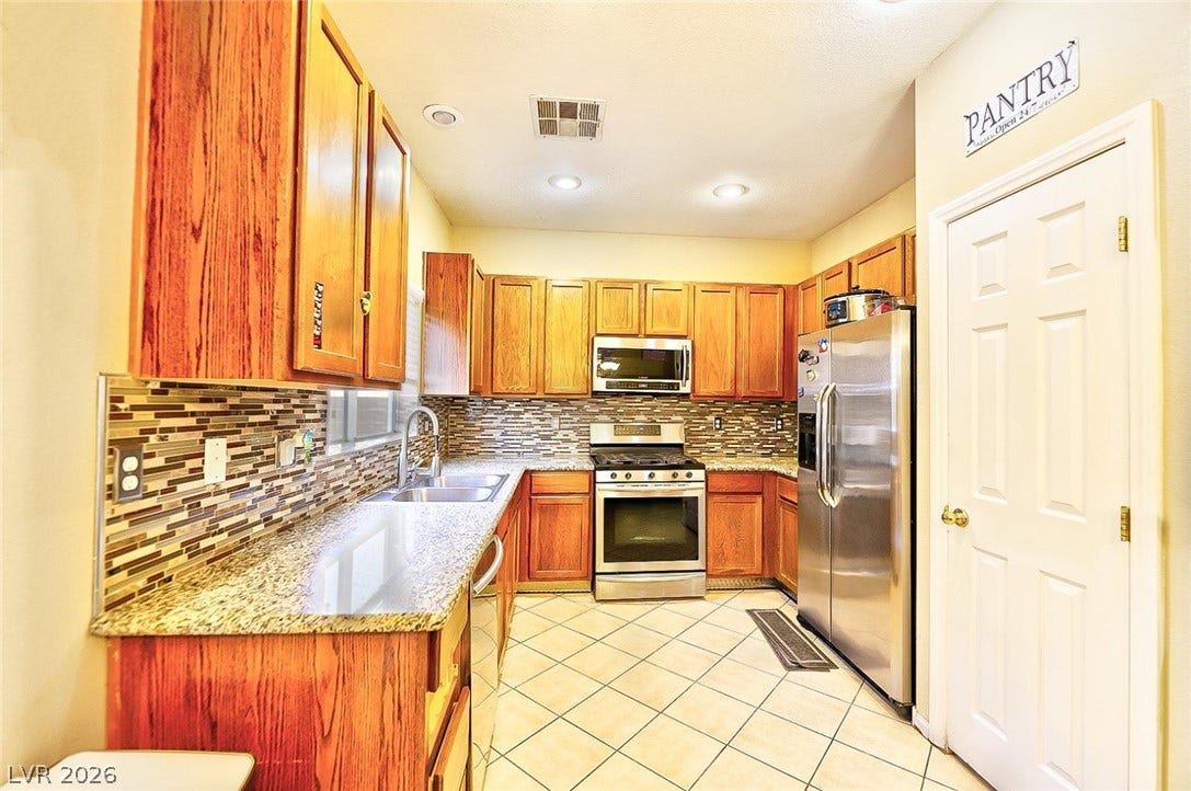 Gleaming stone countertops and classic wood cabinetry define this functional, well-appointed cooking space.