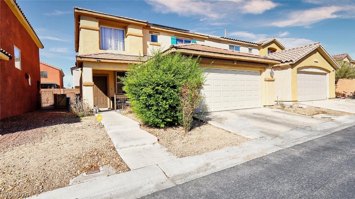 An inviting stucco exterior features a tile roof and a spacious two-car garage.