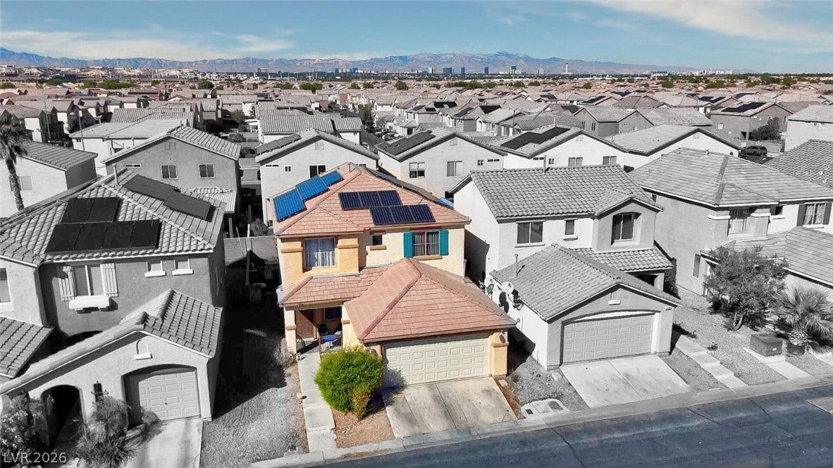 An elevated perspective shows a residential neighborhood with distant mountain views.