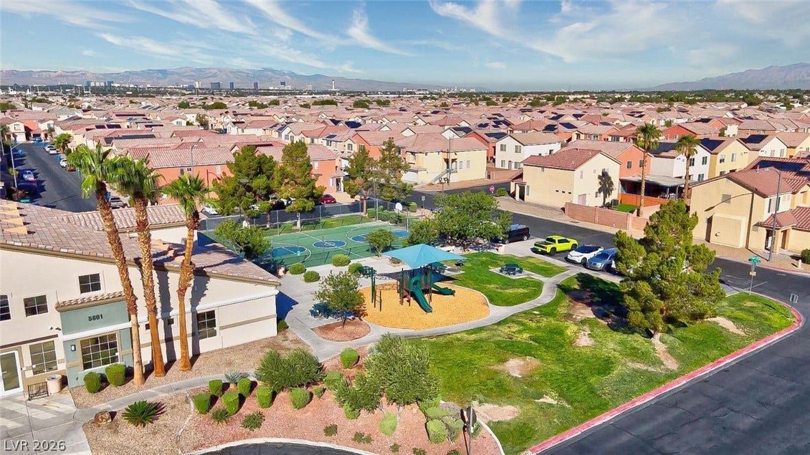 An inviting neighborhood park offers lush green space, a playground, and a basketball court.
