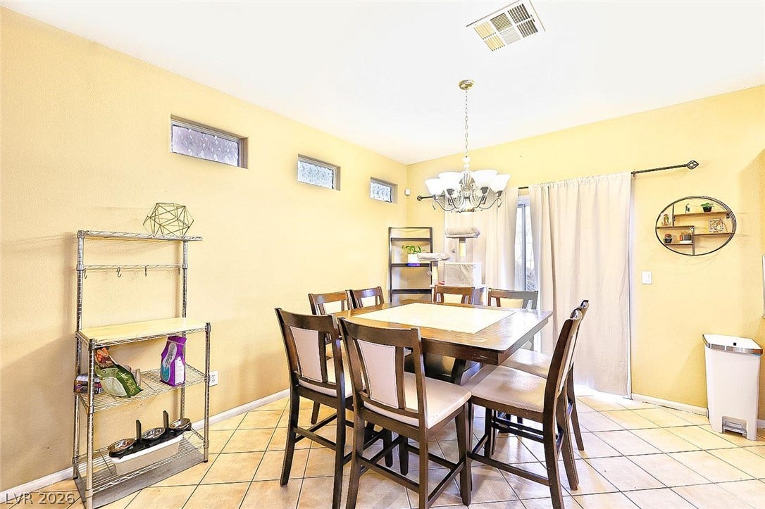 High ceilings and clerestory windows bring abundant natural light into this tiled dining space.