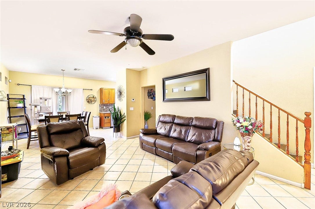 Tiled flooring and a wooden staircase anchor this comfortable, open-concept living area.