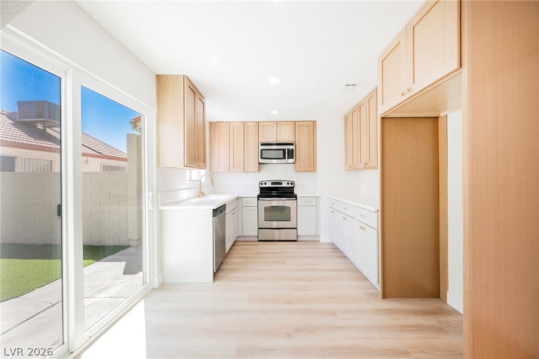 2822 Sesame Drive, Las Vegas, NV 89142 Natural light pours across light wood-look flooring in this modern kitchen with sliding door access.