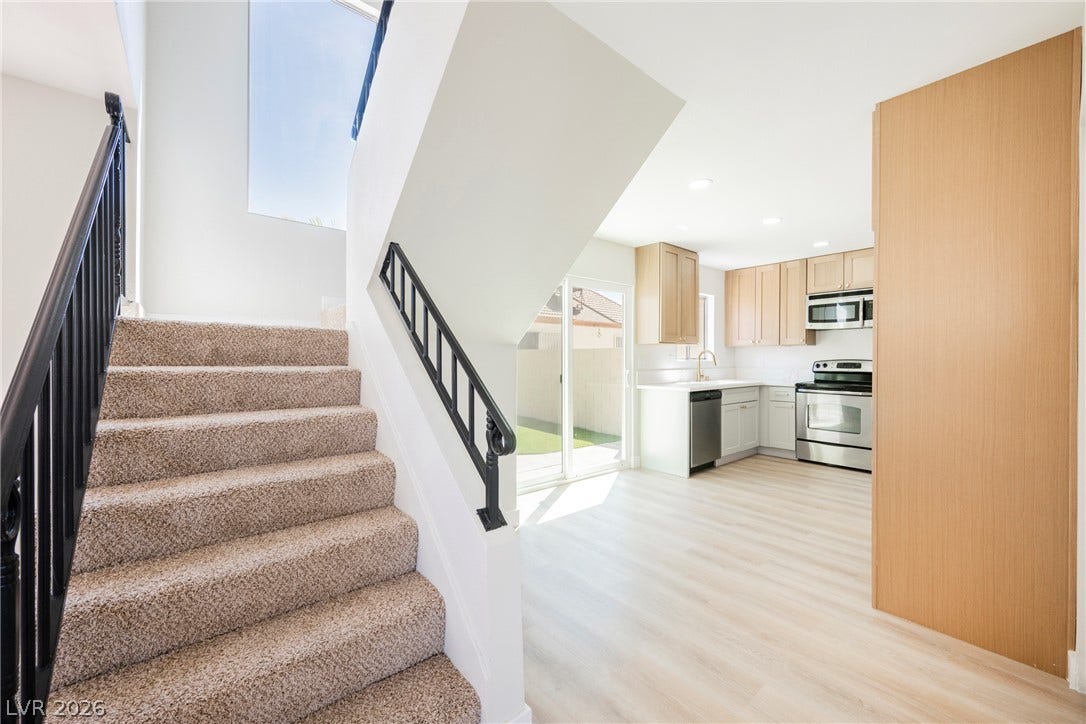 2822 Sesame Drive, Las Vegas, NV 89142 Carpeted stairs lead down to a bright kitchen with light wood-style flooring.