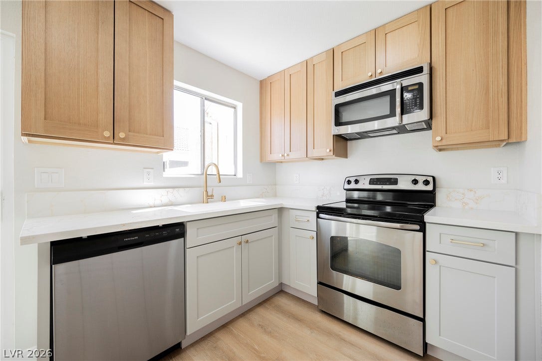 2822 Sesame Drive, Las Vegas, NV 89142 Warm wood upper cabinets pair with crisp white lower cabinetry in this modern kitchen.