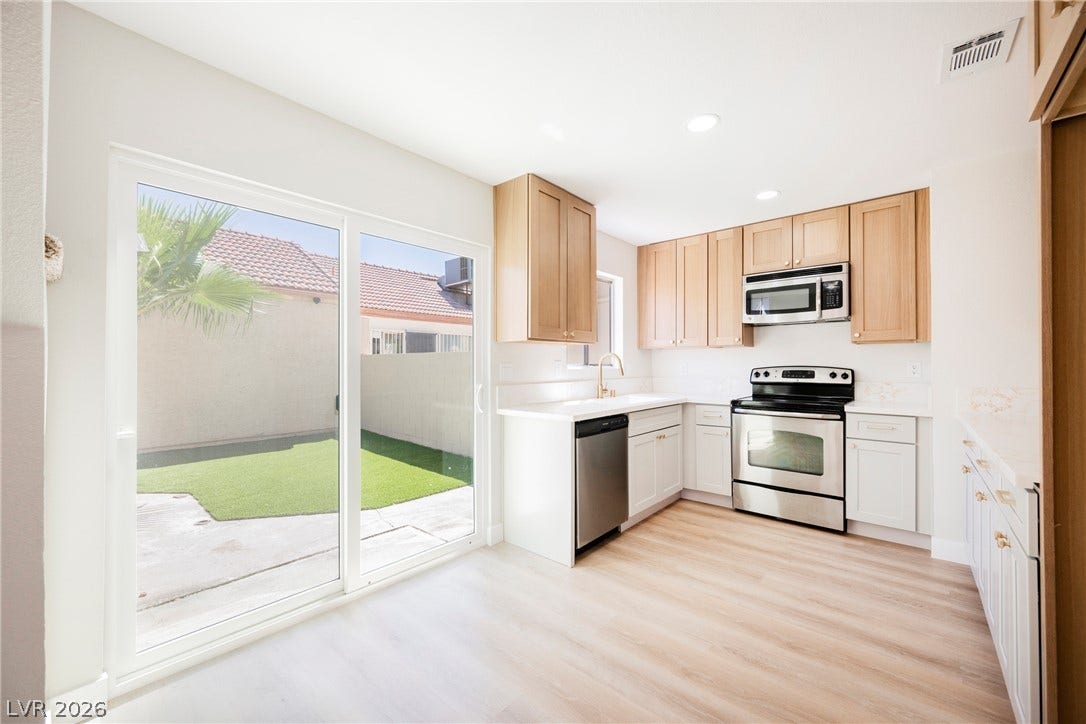 2822 Sesame Drive, Las Vegas, NV 89142 Sliding glass doors connect a modern kitchen directly to the private back patio.