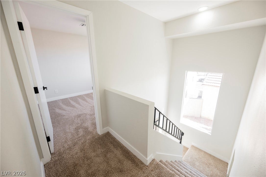 2822 Sesame Drive, Las Vegas, NV 89142 Carpeted stairs lead down past a well-placed window illuminating the upper landing.