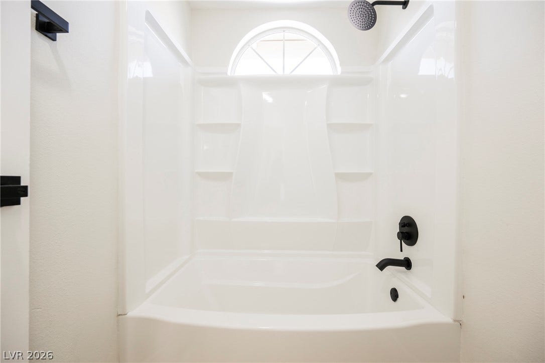 2822 Sesame Drive, Las Vegas, NV 89142 An arched window brings natural light into the tub and shower combination.