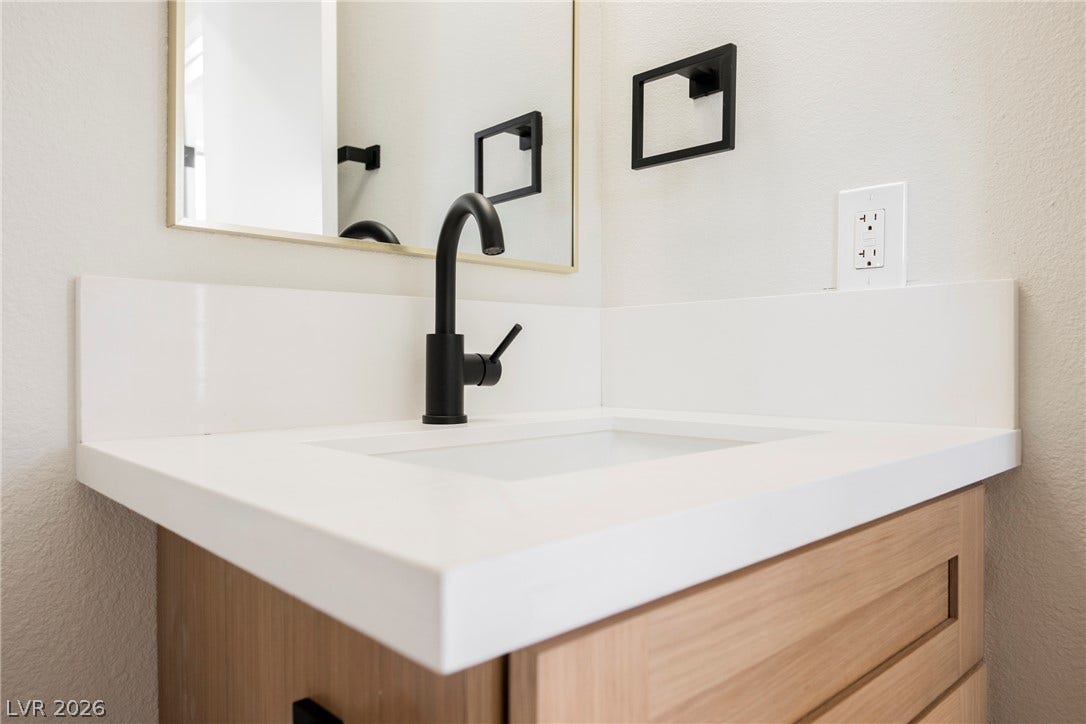 2822 Sesame Drive, Las Vegas, NV 89142 A modern vanity anchors this washroom with a clean stone counter and sleek black hardware.