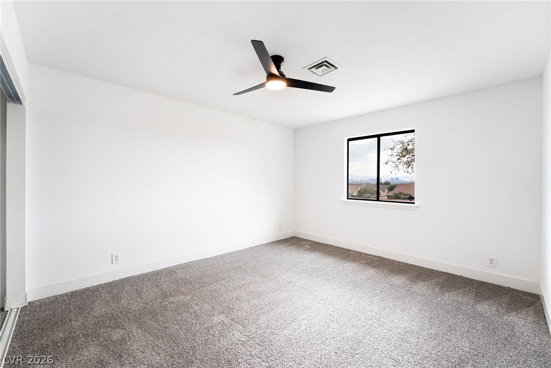 Plush carpeting and a picture window overlooking neighborhood views define this versatile secondary bedroom.