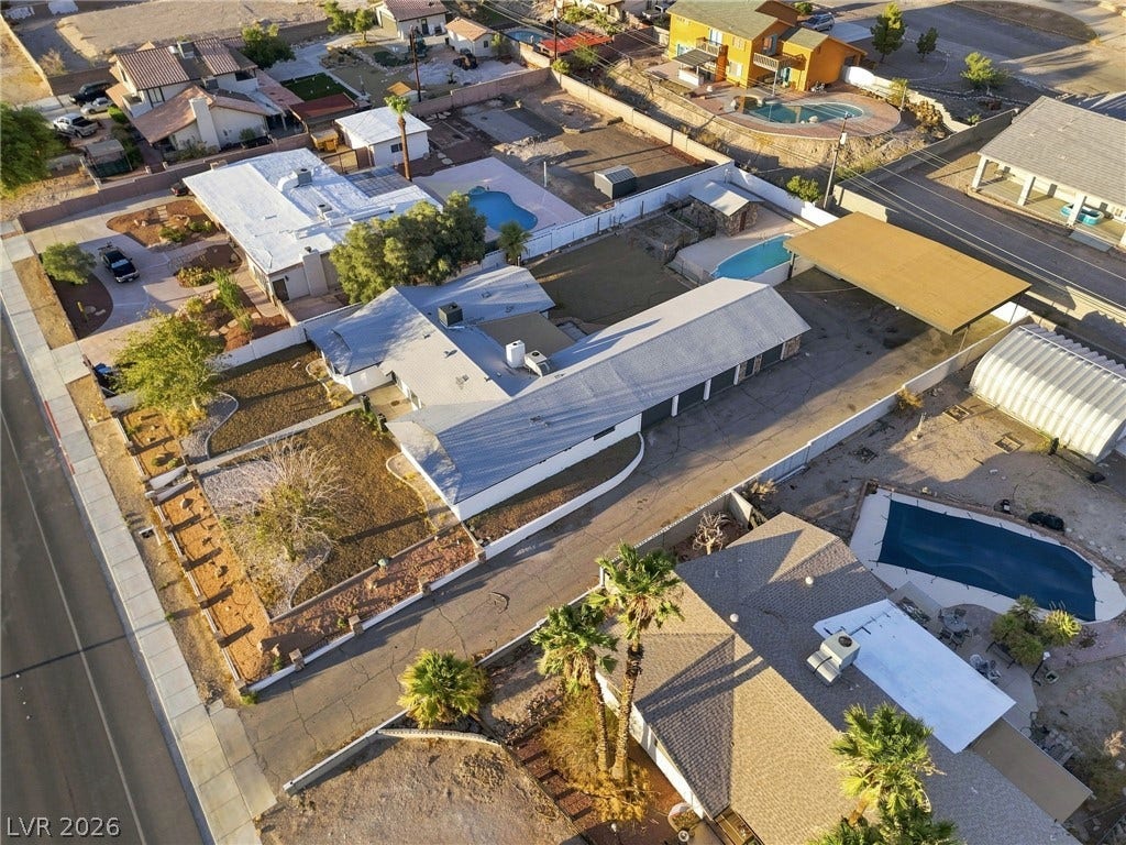 An aerial perspective showcases the spacious lot, paved driveway, and private yard with mature trees.