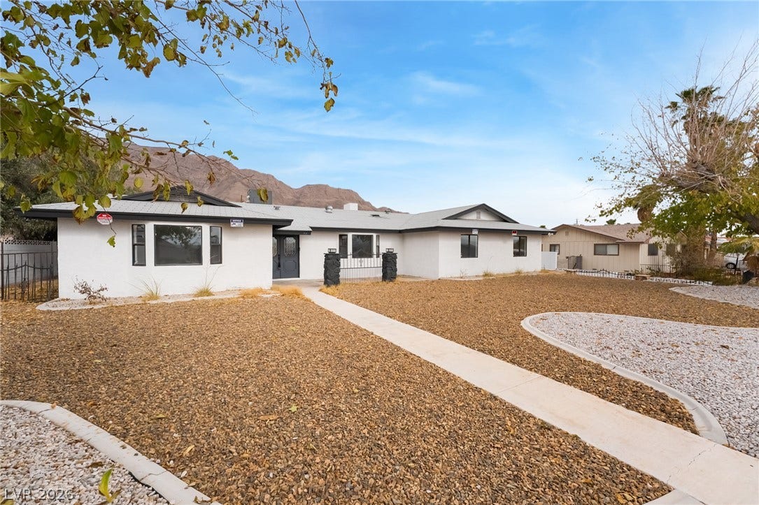 Low-maintenance desert landscaping frames the single-story exterior of this charming residence.