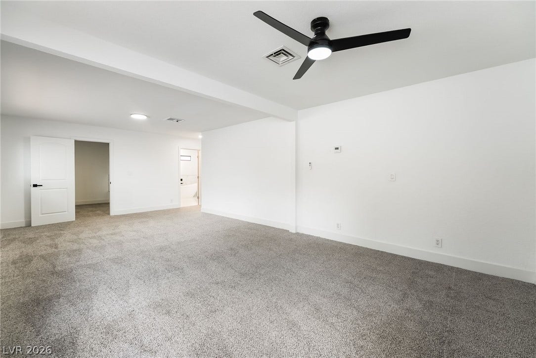 An open floor plan connects the versatile living spaces over comfortable carpeting.