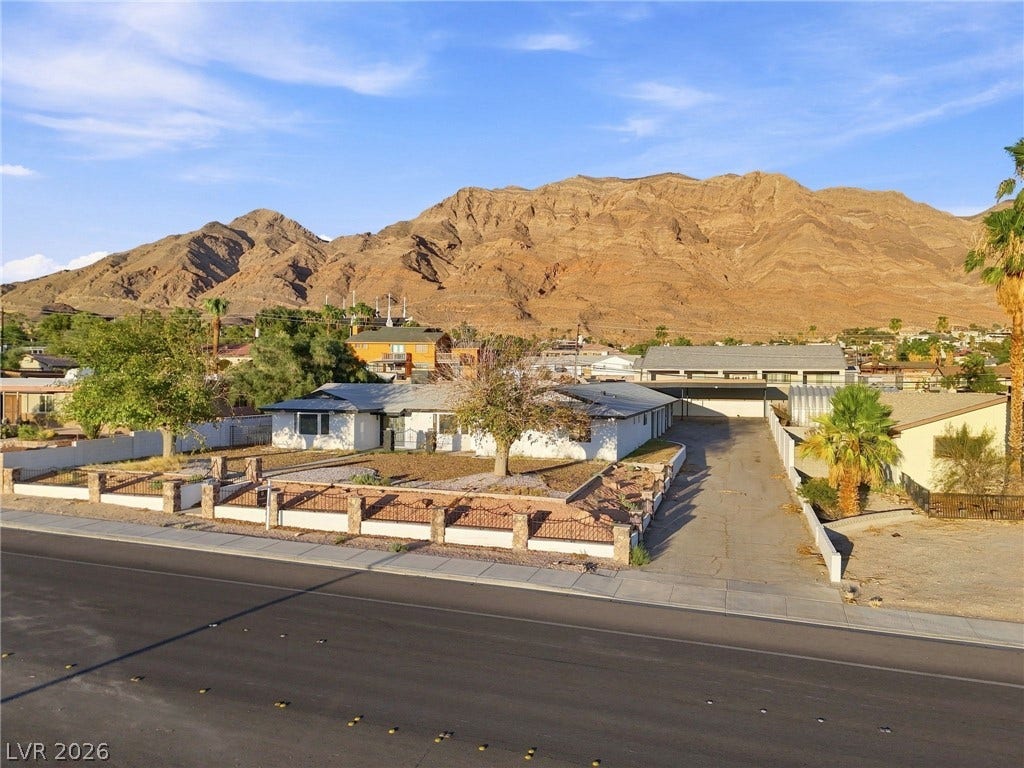 Dramatic mountain ridges frame this single-level home set behind a gated perimeter wall.