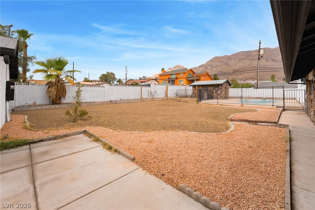 An expansive backyard features mountain views, low-maintenance landscaping, and a fenced swimming pool area.
