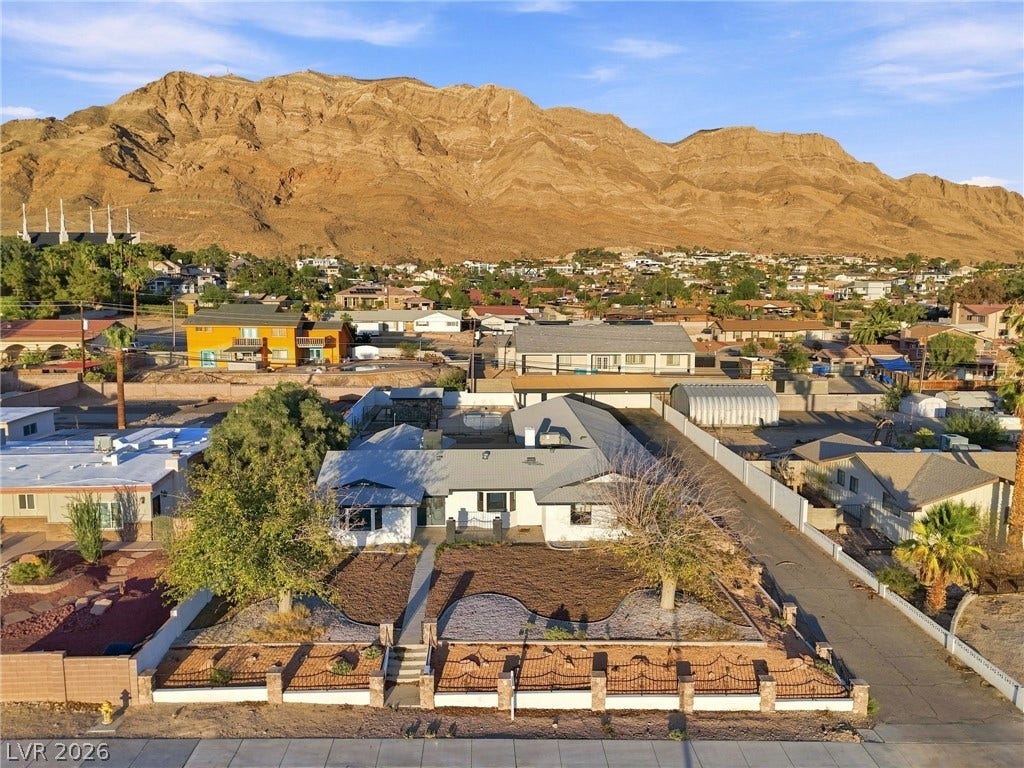 Nestled beneath a dramatic mountain backdrop, this classic single-story home sits on a manicured lot.