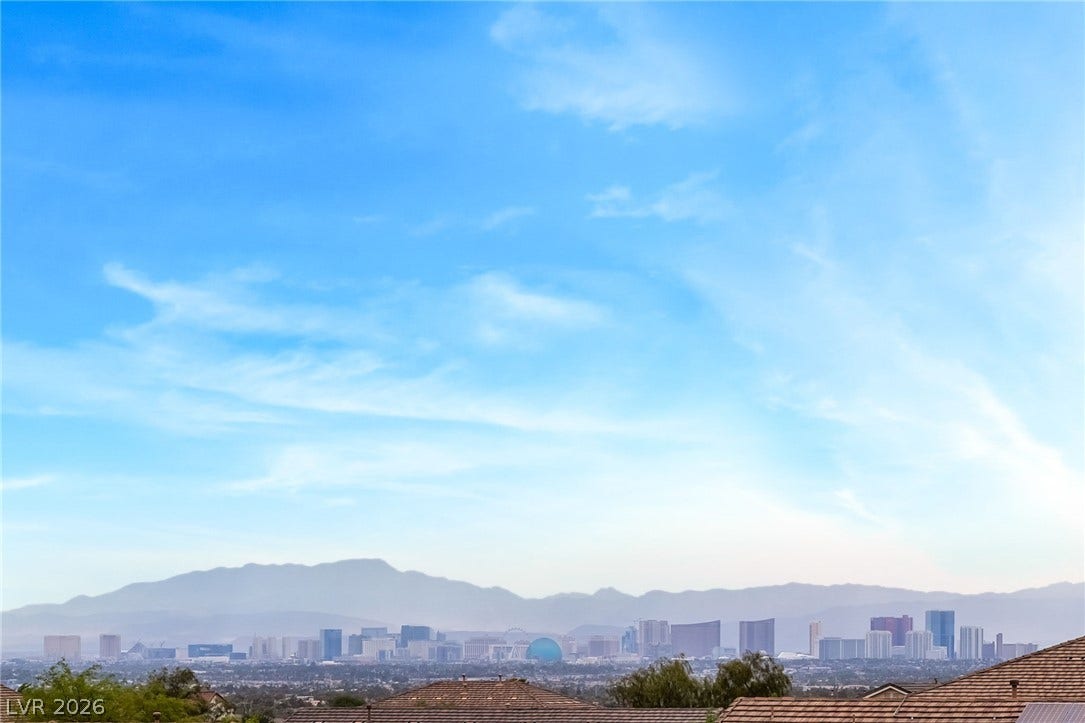 A sweeping panorama reveals distant city skylines set against a majestic mountain backdrop.