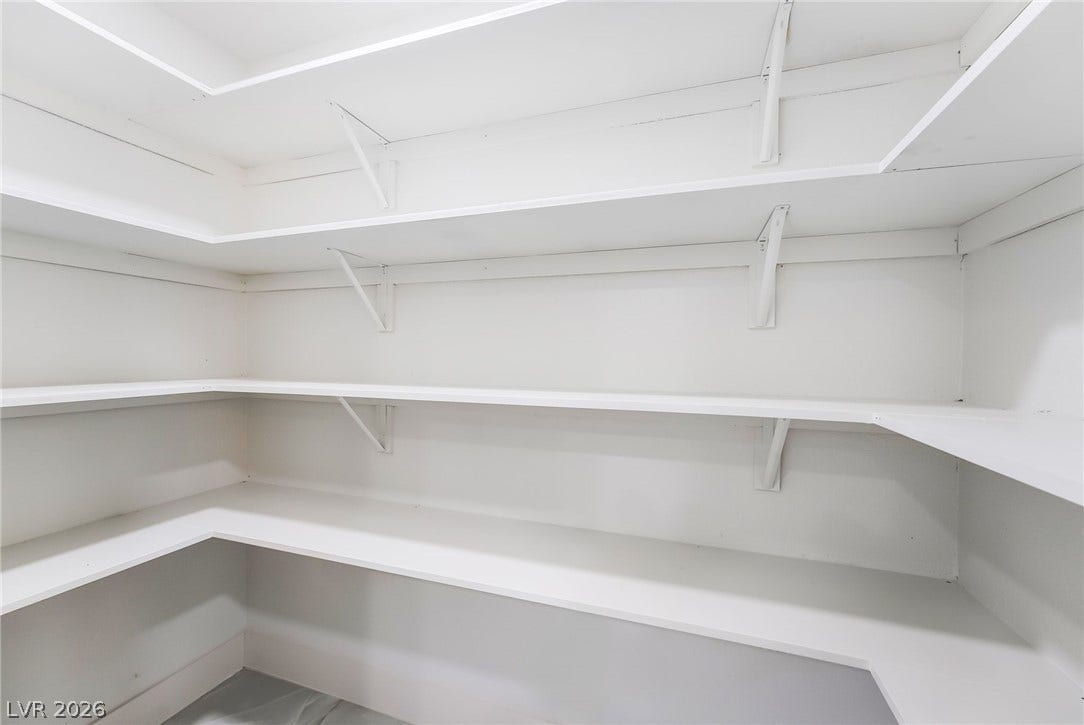 Abundant built-in shelving wraps around this functional walk-in storage area.
