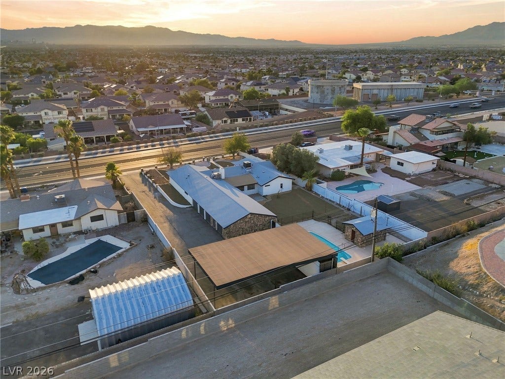 Panoramic mountain and neighborhood vistas surround this property at sunset.