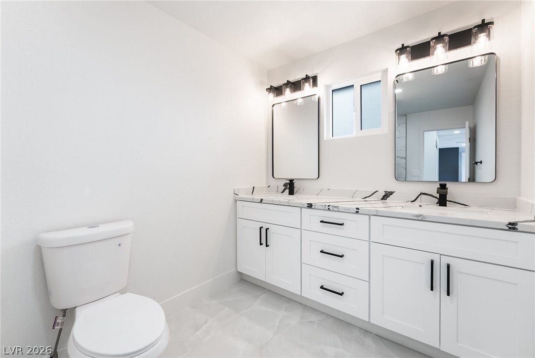 Clean lines and a spacious dual vanity highlight this modern washroom design.
