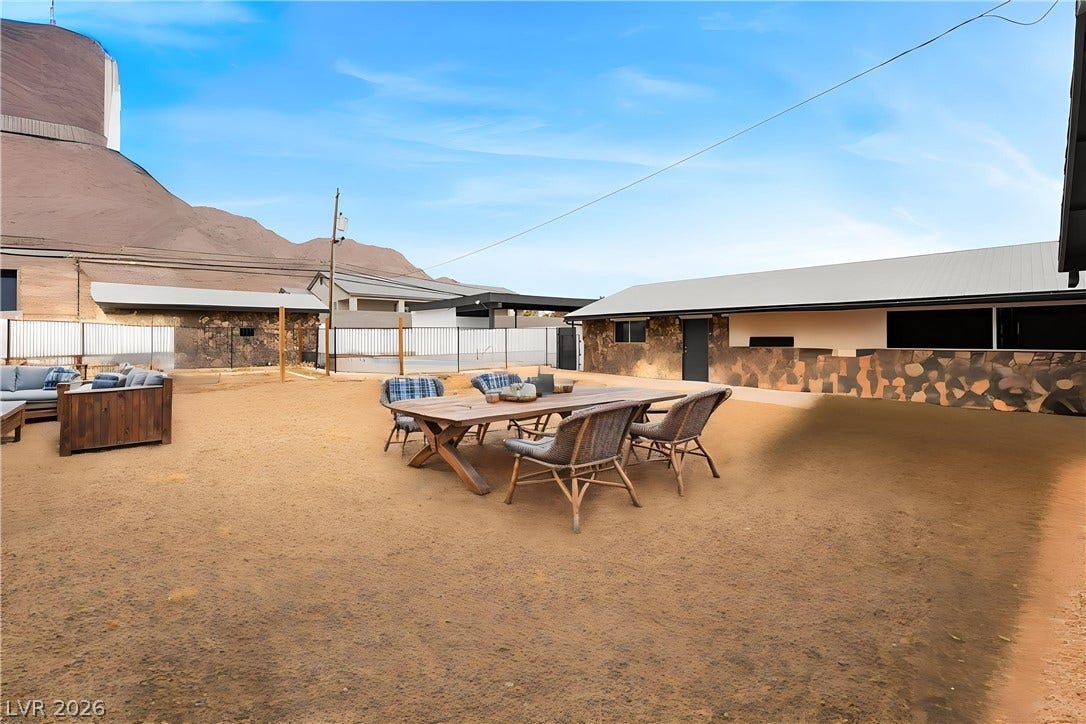 An expansive outdoor patio area rests beneath sweeping desert mountain views.