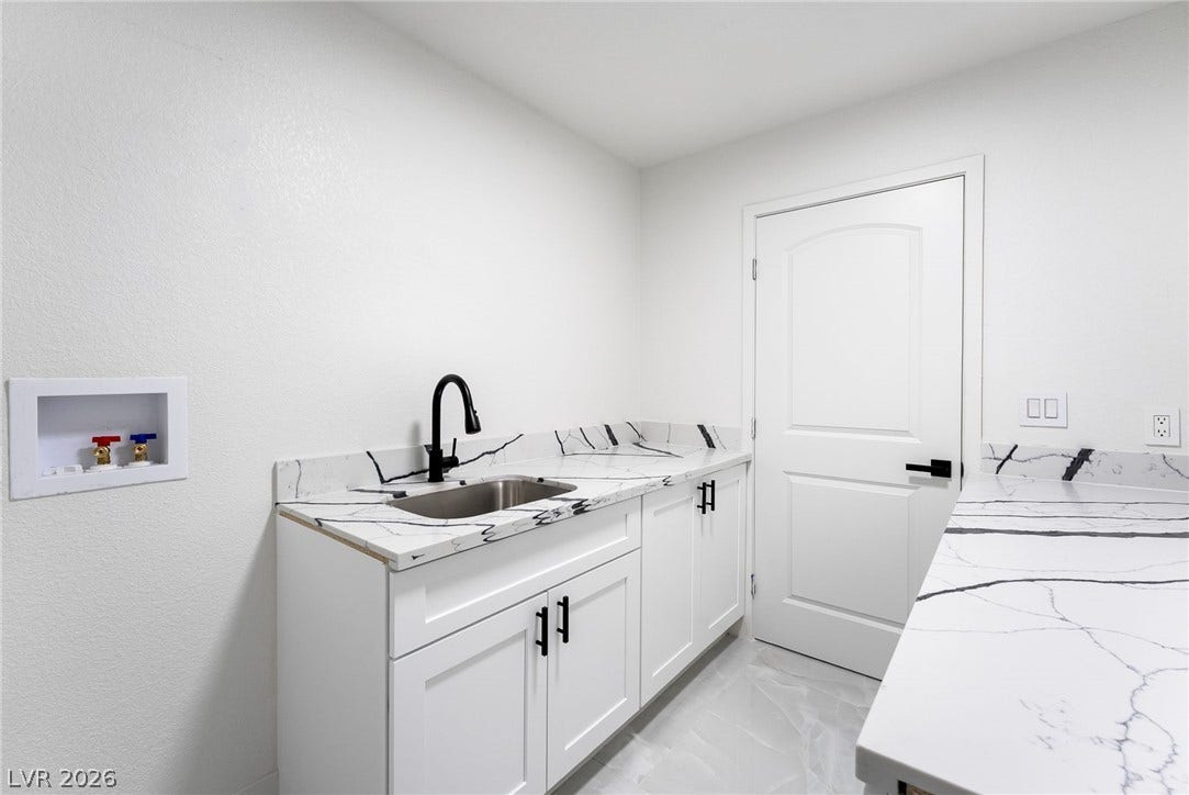 Sleek countertops and a deep utility sink elevate this functional utility space.