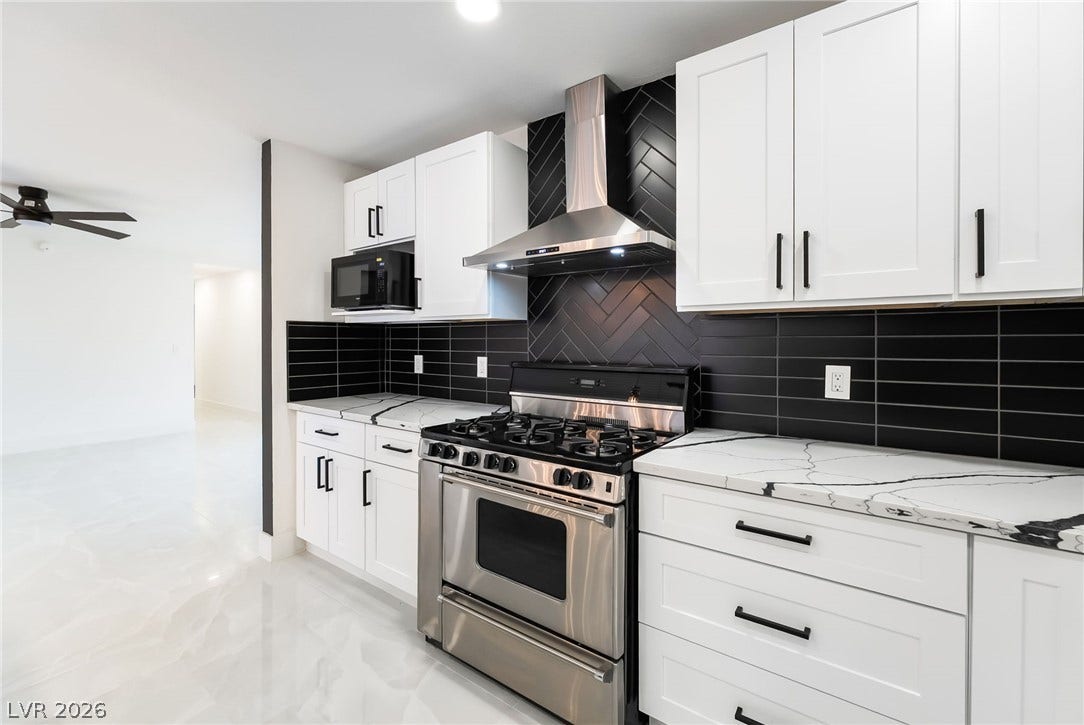 Sleek stone countertops and contrasting dark tiled backsplashes elevate this modern culinary space.