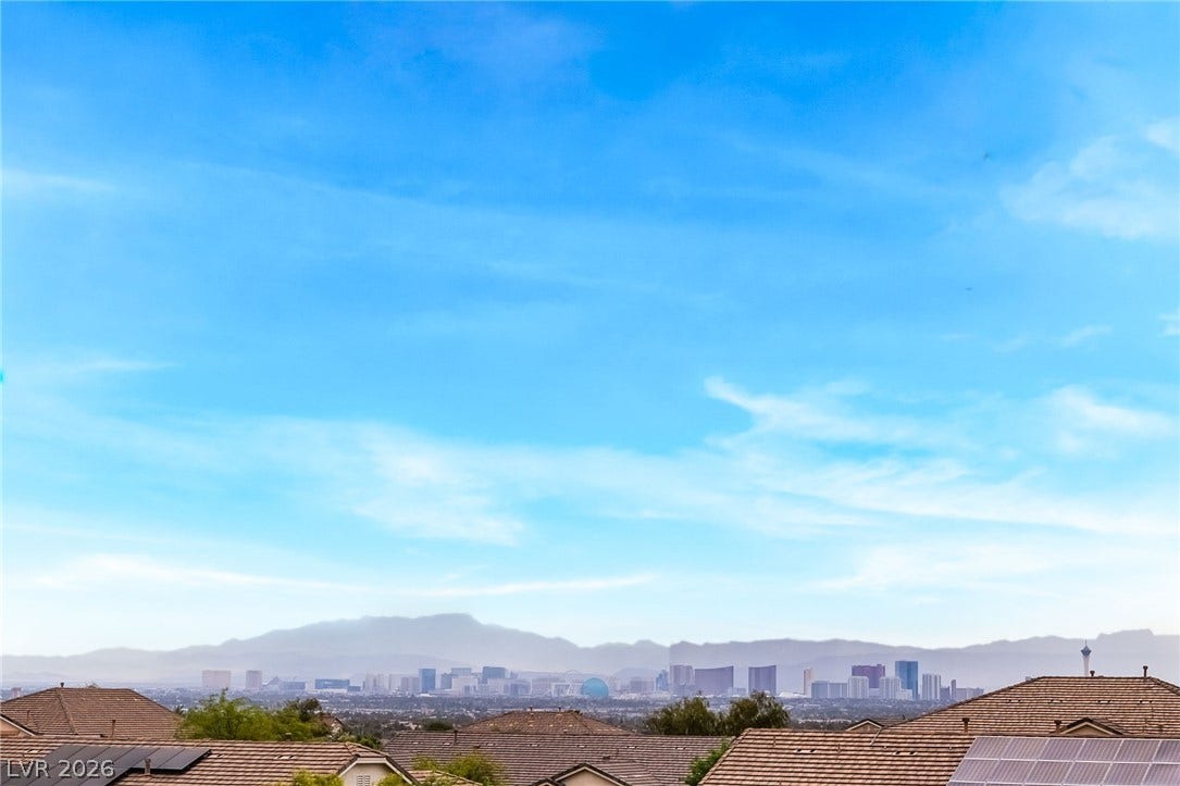 Far-reaching mountain and city skyline views stretch out under a wide desert sky.