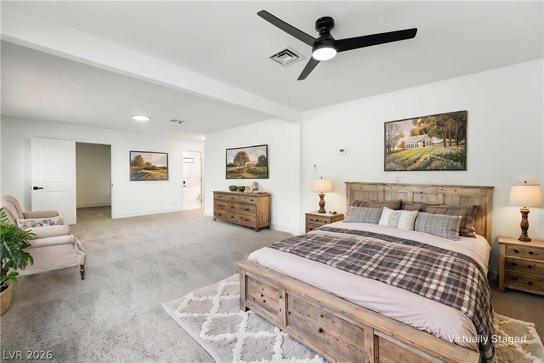 Plush carpeting anchors this generously proportioned sleeping quarters featuring high ceilings.