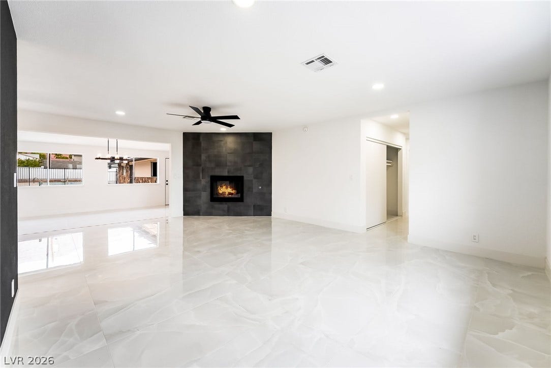 Polished tile flooring and a contemporary tiled fireplace anchor this expansive, open living area.