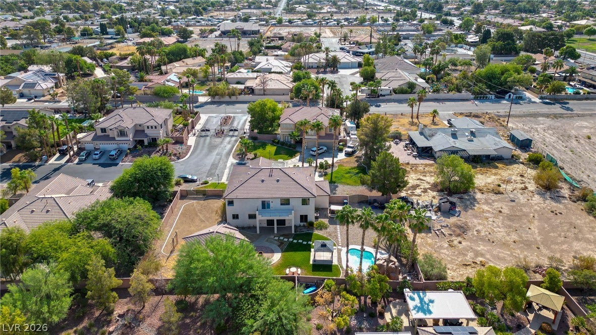 An aerial perspective reveals the residential landscape surrounding this multi-level home with a pool.