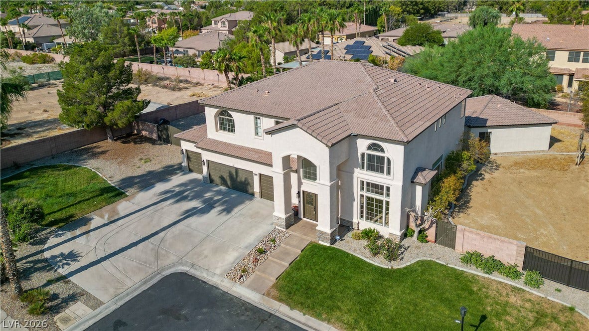 An elegant tile roof and grand arched entryway define this striking two-story residence.