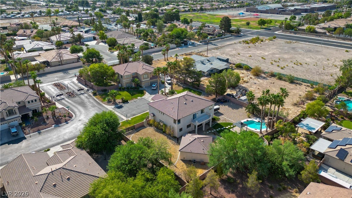 An aerial perspective captures the tiled rooflines, private swimming pool, and surrounding desert neighborhood.