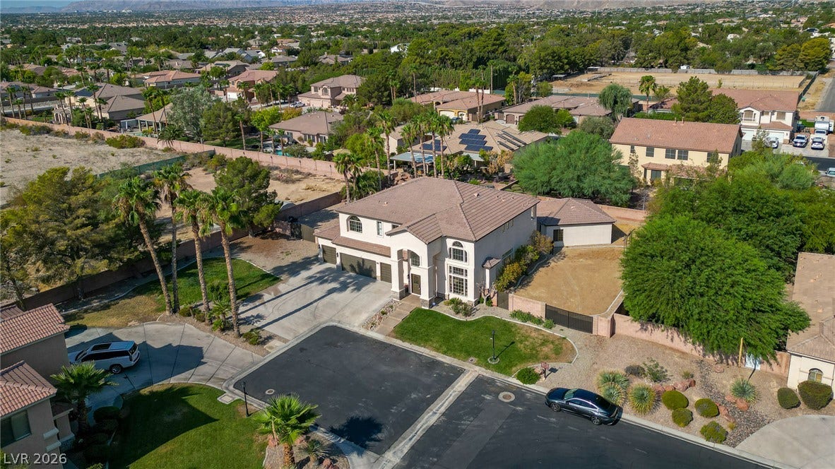An aerial perspective captures the tiled roofline and paved driveway of this suburban residence.
