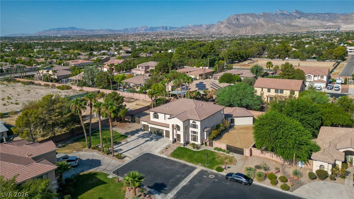 Majestic mountain peaks rise behind this grand suburban estate and its surrounding neighborhood.