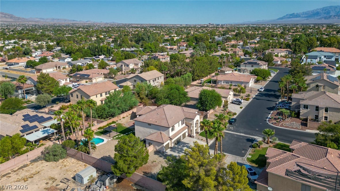 An aerial perspective showcases a quiet residential neighborhood nestled against a scenic mountain backdrop.